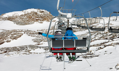 Fototapeta premium Young couple elevating on chairlift