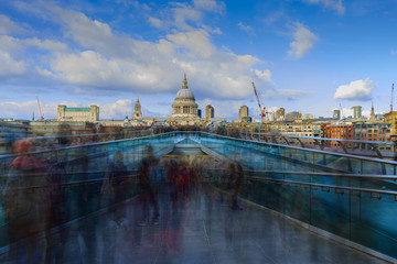 People walking over Millennium bridge in London, England UK. St