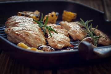 Grilled chicken with mushroom and rosemary on a iron skillet or grill pan