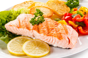 Grilled salmon and vegetables on white background