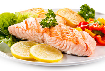 Grilled salmon and vegetables on white background