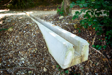 Concrete storm rain drainage on a footpath in the forest.