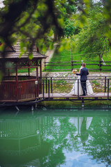 Obraz premium Groom and Bride in a park. wedding dress. Bridal wedding bouquet of flowers. Newlyweds on nature.