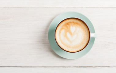Mousse de cappuccino, vue de dessus de tasse de café sur le fond en bois blanc