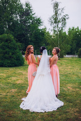 Bride with bridesmaids on the park on the wedding day