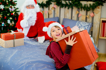 Obraz premium Santa Claus and cute boy getting ready for Christmas
