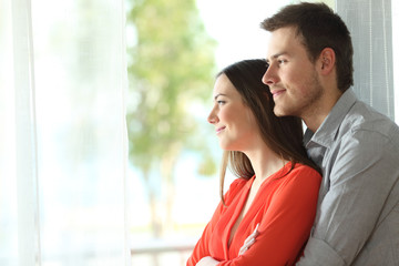 Marriage looking through a window at home