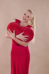 Beautiful young woman in a bright red slinky dress hugging a plu