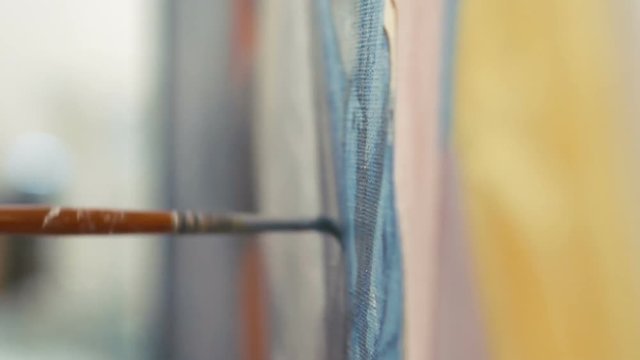 Close up of painter draws picture with paintbrush