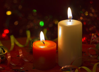 Obraz na płótnie Canvas Christmas and New Year`s festive evening burning candle bokeh image. Greeting card lights Background concept with holiday tinsel, twisted ribbons and copyspace place for text or logo.