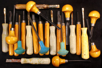 Many old art chisels on black background