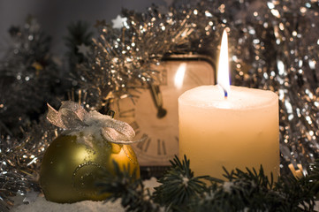 Christmas and New Year`s vintage clock showing five to midnight. Christmas toy ball and fir tree branches covered with snow. Congratulations background with holiday tinsel, copyspace for text or logo.