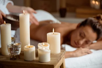 Zelfklevend Fotobehang Badkamer Young beautiful girl relaxing in spa salon. Focus on candles.  © Cookie Studio