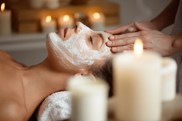 Young beautiful girl in mask for face relaxing in spa salon.
