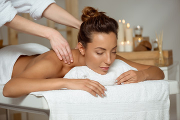 Young attractive girl having massage relaxing in spa salon.