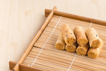Crispy roll with dried shredded pork on a bamboo dish.