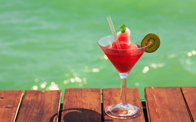 Frozen Strawberry Daiquiri cocktail on the wooden pier. Concept