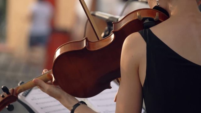 Girl playing the violin in the day, violinist is a professional musician