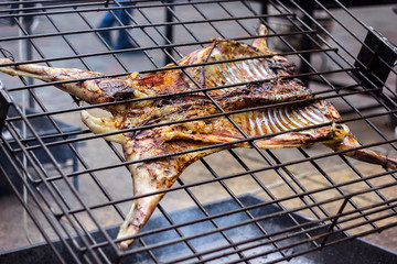 Appetizing grilled lamb on the spit. Roasted pig on traditional barbecue. Roasting barbecue is...