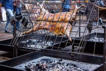 Appetizing grilled lamb on the spit. Roasted pig on traditional barbecue. Roasting barbecue is prepared of a ram pig baked pork meat Street food Whole carcass pig roasting on the grill over charcoal.