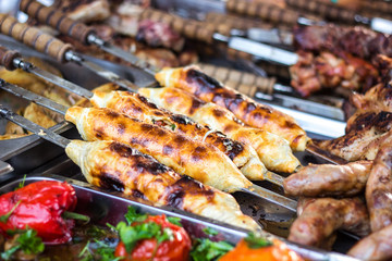 Georgian traditional dish - khachapuri, pastry with cheese tomatoes on a skewer fried on the grill. Fresh hot tasty street food in the market. Cooking food. Preparation dish of Middle Eastern cuisine.