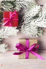 Gift boxes and christmas tree branches over old wooden backgroun