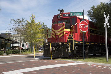 Naklejka premium Mount Dora Florida USA - October 2016 - A freight pulling locomotive passing through the center of Mount Dora a small Florida town.