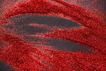 Red glitter sand texture on black, abstract background.