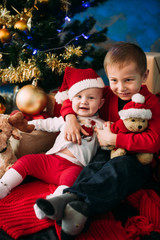 Portrait of happy children with Christmas gift boxes and decorations. Two kids having fun at home