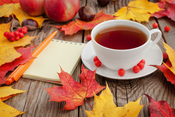 Cup of coffee, framed with autumn leaves on white background. Flat lay. Top view