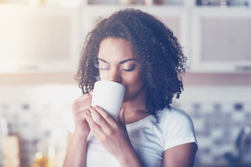 Pleasant young woman drinking coffee