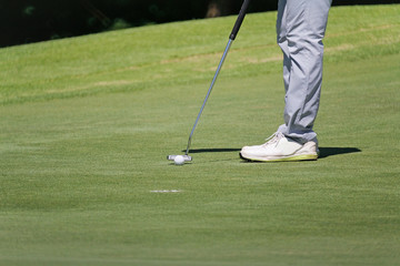 Plakat golfer putting, selective focus on golf ball