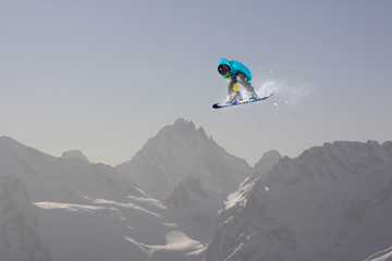 Naklejka na ściany i meble Snowboard rider jumping on mountains. Extreme snowboard sport.