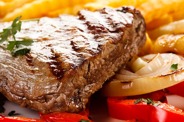 Grilled steak, French fries and vegetables 