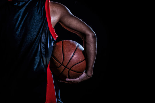basketball player with a ball on dark background
