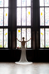 beautiful young girl opened the curtains and looks out the window. bride waiting for groom