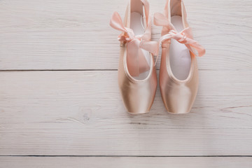 Pink ballet pointe shoes on white wood background © Prostock-studio