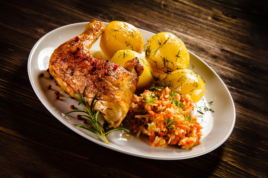 Grilled chicken leg with boiled potatoes and vegetable salad 