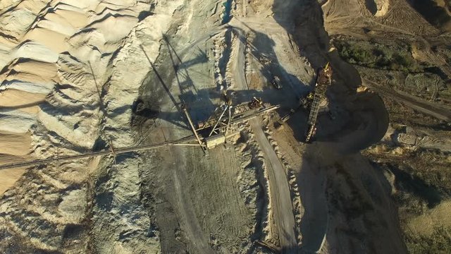 Flying over the iron ore quarry. Excavator digs for iron ore quarry. aerial survey