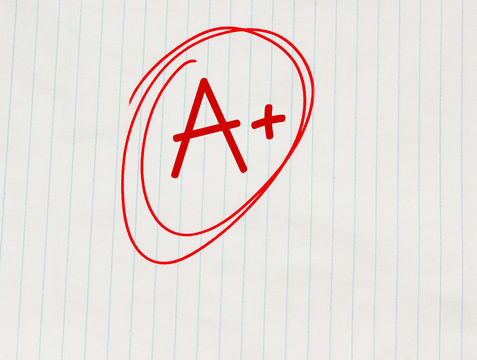 A plus (A+) grade written in red on notebook paper