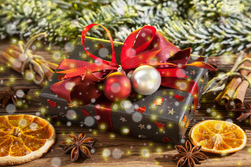 Fototapeta na wymiar graues Weihnachtspäckchen close up, auf weihnachtlichem Holztisch mit Schneefall
