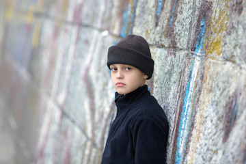 dramatic portrait of a little homeless boy on the street