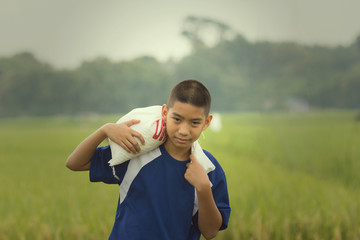 Fototapeta premium The face of boy has the drop of sweat represent his tired after working hard in his family farm
