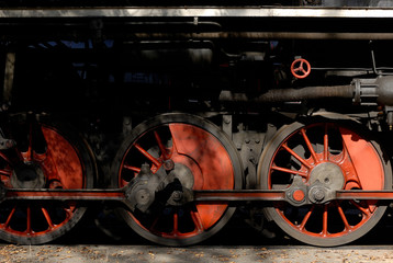 Steam locomotive wheels and rods closeup. Detail of mechanical parts, wheels and equipment of the train.