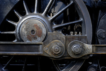 Steam locomotive wheels and rods closeup. Detail of mechanical parts, wheels and equipment of the train.