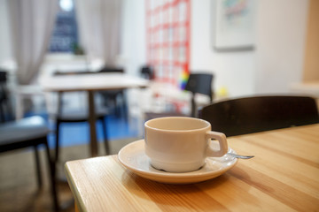 Cup of coffee in cafe on the table, blurred background