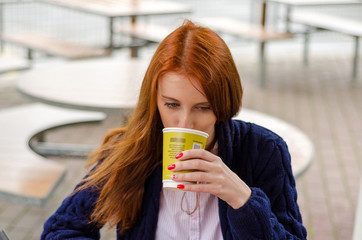 Young red woman with hot coffee
