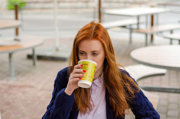 Young red woman with hot coffee