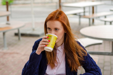 Young red woman with hot coffee