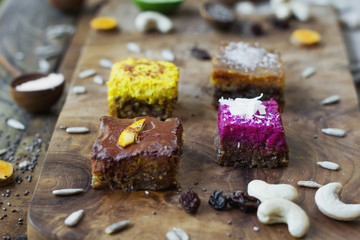 Four pieces of different raw cakes on wooden brown board